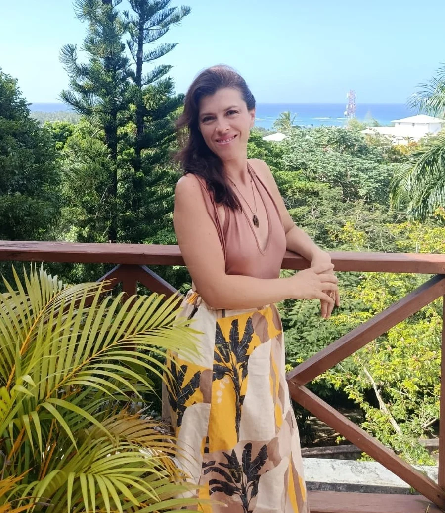 Ana Cristina standing on a tropical balcony